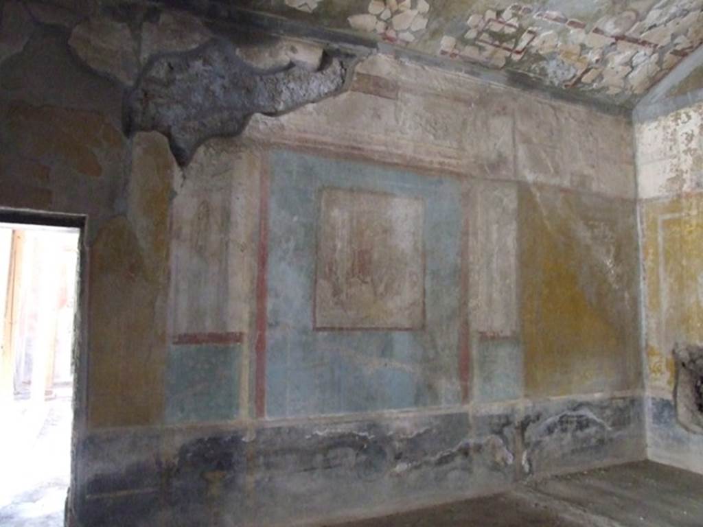 I.10.11 Pompeii. March 2009. Room 8, remains of central wall painting of Ariadne and Dionysus, from south wall of triclinium.  
See Bragantini, de Vos, Badoni, 1981. Pitture e Pavimenti di Pompei, Parte 1. Rome: ICCD.  (p.143).
Kuivalainen describes –
“A composition of at least five figures. In the right corner foreground is a reclining female with her face towards the viewer; her yellow cloak covers her legs and is lifted by a cupid, who stands behind her. In the middle, a standing youth watches the sleeping female. Next to him stand two others, one wearing a red cloak down to the hips.”
Kuivalainen comments –
“The foremost figure in the middle is Bacchus, and the one in the red cloak is Silenus. The pictorial programme of the room may concentrate on abandoned lovers, even if a better destiny awaits Ariadne.”
See Kuivalainen, I., 2021. The Portrayal of Pompeian Bacchus. Commentationes Humanarum Litterarum 140. Helsinki: Finnish Society of Sciences and Letters, (p.147, E8).

