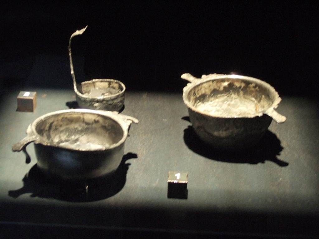 I.11.5 Pompeii. Silver found in south east corner of the atrium. A simpulum, to left rear, Inventory number 12814. Skyphos (cup). SAP Inventory number 12813. Skyphos (cup). SAP Inventory number 12812.