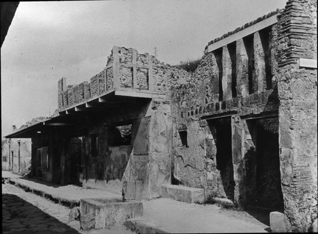 I.12.1 and I.12.2 Pompeii, on right.  Entrances on Via dell’ Abbondanza, with fountain outside. Looking east. Photo by permission of the Institute of Archaeology, University of Oxford. File name instarchbx202im 001. Resource ID. 44520.
