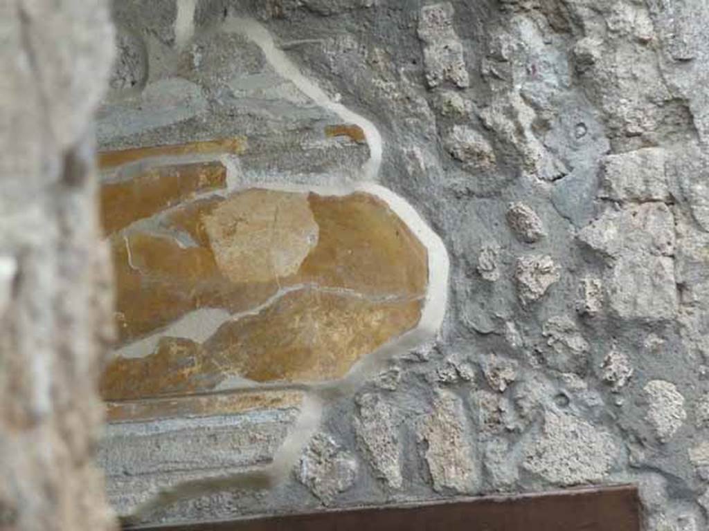 I.13.2 Pompeii. May 2010.  Remains of painted wall plaster above small doorway to anteroom, on east side of atrium.