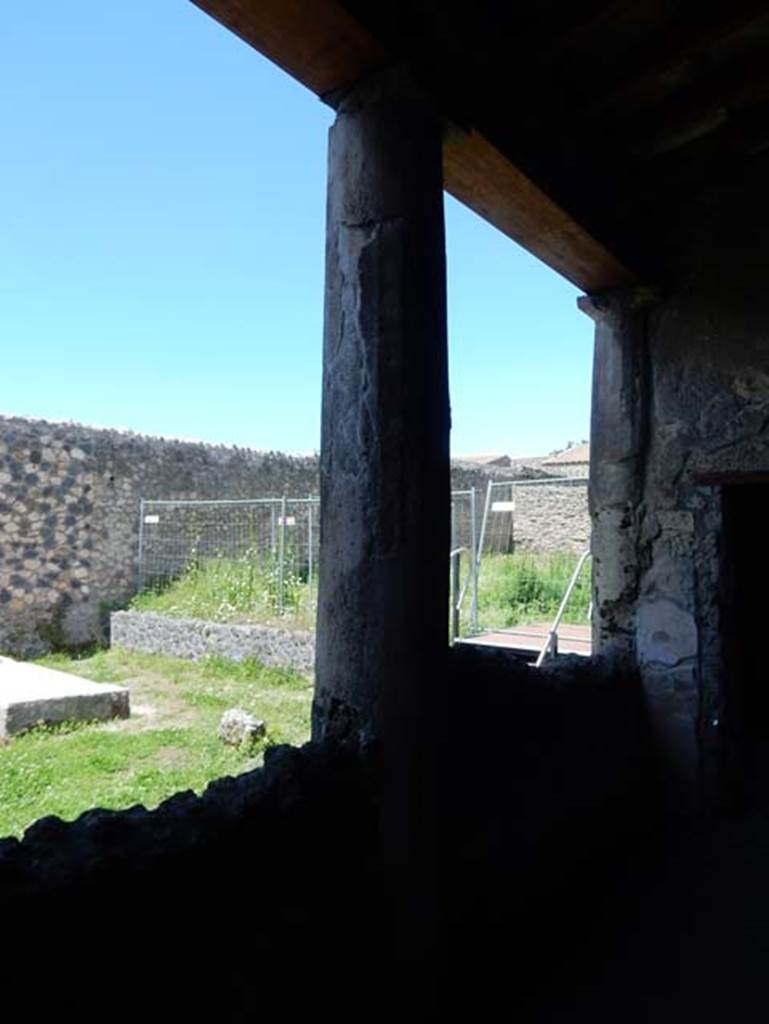 I.14.12, Pompeii. May 2018. 
Room 32, looking north-west across east portico, with pluteus (wall of peristyle built between columns) towards adjoining garden of I.14.1.
Taken from near doorway to room 2, on right.  Photo courtesy of Buzz Ferebee

