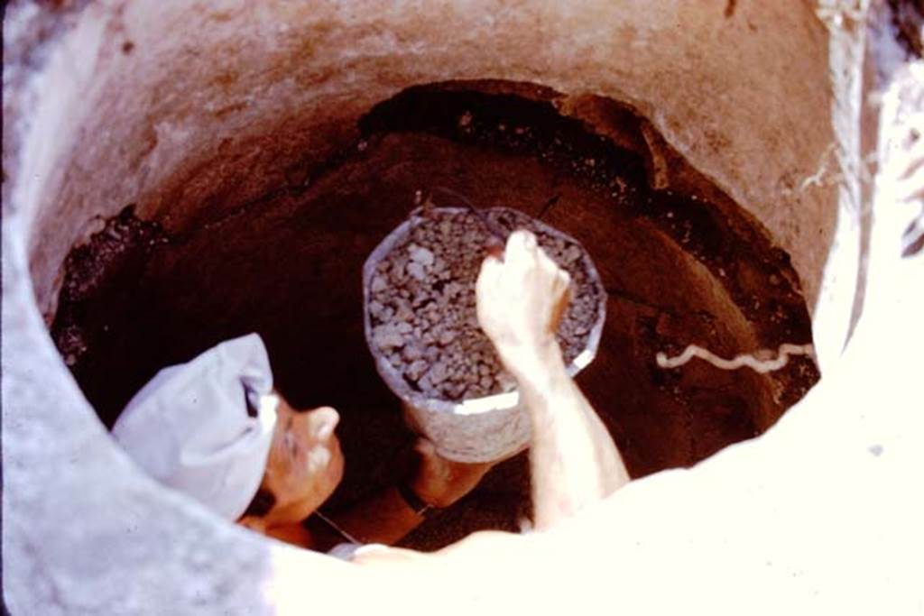 I.20.5 Pompeii. 1972. Worker inside the cistern handing up the bucketful of lapilli. Photo by Stanley A. Jashemski. 
Source: The Wilhelmina and Stanley A. Jashemski archive in the University of Maryland Library, Special Collections (See collection page) and made available under the Creative Commons Attribution-Non Commercial License v.4. See Licence and use details. J72f0160
