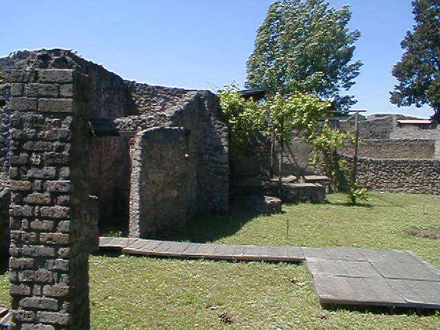II.1.8 Pompeii. May 2005. Looking north-west from doorway. According to Jashemski, the small room on the left side of the entrance doorway was excavated in 1985. It was found to have a treading floor, where grapes were pressed by foot. The juice flowed into a small dolium. The presence of the treading floor suggested that the garden had been planted in vines to provide grapes for wine that was made on the site. See Jashemski, W. F., 1993. The Gardens of Pompeii, Volume II: Appendices. New York: Caratzas. (p.75) See II.1.9 for more photos, and that the garden has now been replanted in vines.