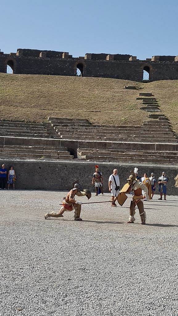 II.6 Pompeii. September 2024. 
Looking west towards Gladiators in combat rehearsing.  
Photo courtesy of Giuseppe Ciaramella.
