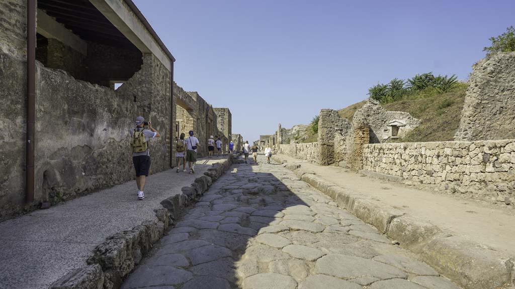 III.7.5 Pompeii, wider threshold in newly constructed wall, right of centre of photo. August 2021. 
Looking west along newly constructed wall along III.7 on north side of Via dell’Abbondanza (on right). II.4.7 is on the left. 
Photo courtesy of Robert Hanson.

