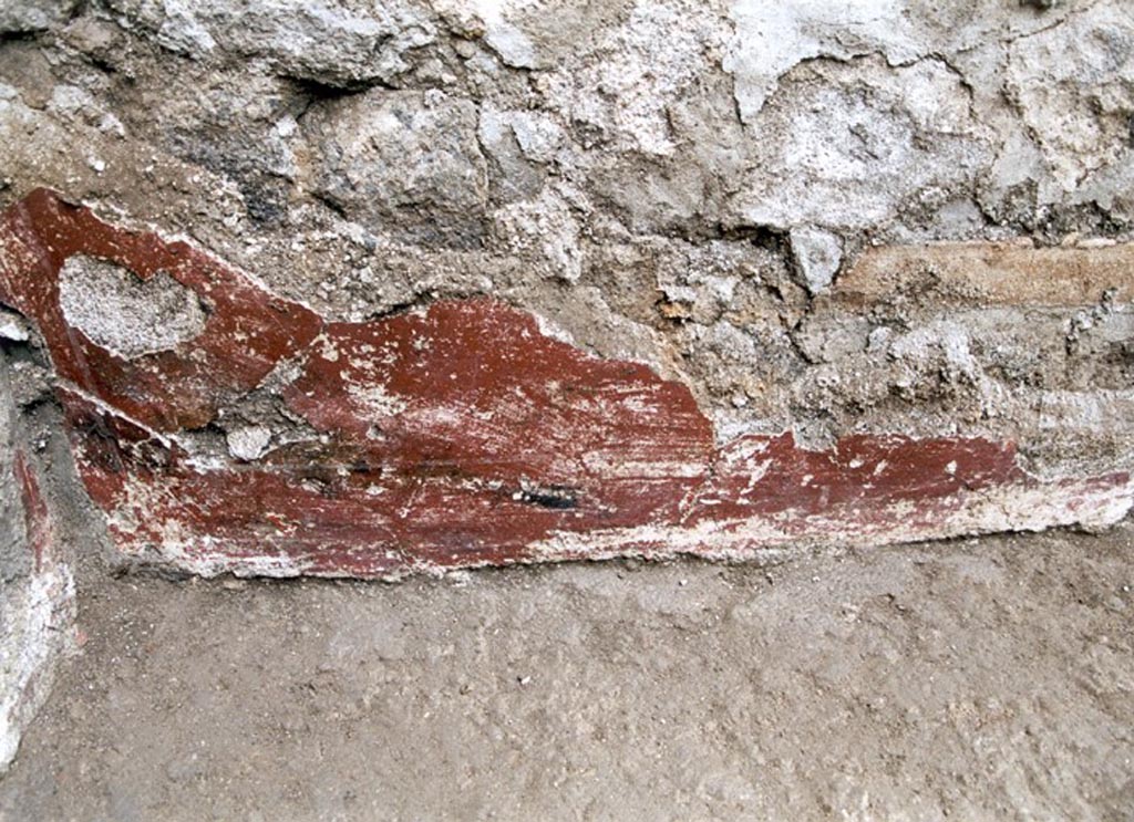 V.1.15 Pompeii. Not dated. 
West wall in south-west corner, detail of remaining red-coated plaster decoration. 
Photo by Henrik Boman. 
Photo courtesy of the Swedish Pompeii Project.
