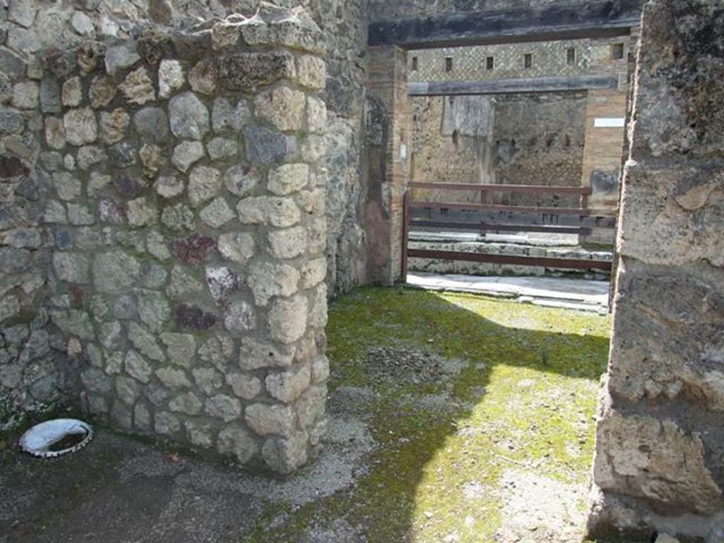 V.1.15 Pompeii. April 2009. Doorway to room on south side of entrance, leading into V.1.16. Looking west.
According to Boyce, in this area should have been the lararium, presumably destroyed in 1943. He described it as being in a house transformed into a workshop. In the west wall of the atrium, near the south-west corner was a rectangular niche with aedicula façade and projecting floor. The inside walls were painted blue and the opening of the niche was outlined with red stripes on the white background of the wall of the room.
See Boyce G. K., 1937. Corpus of the Lararia of Pompeii. Rome: MAAR 14. (p.32, no.74) 
