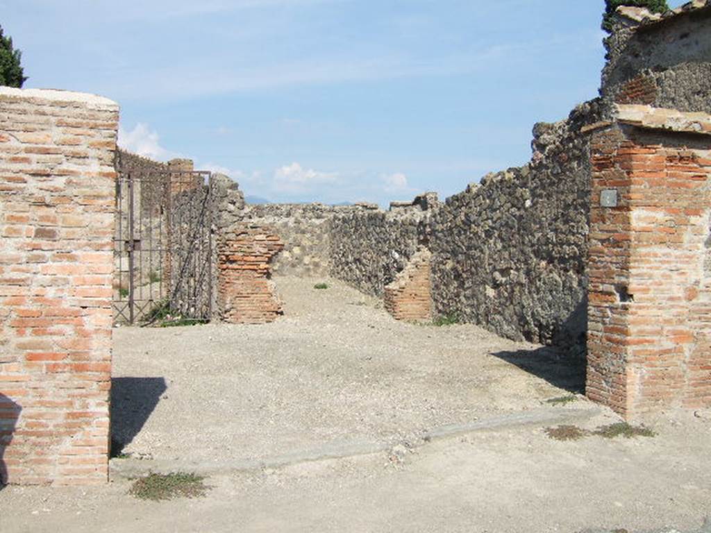 VI.1.4 Pompeii. September 2005. Entrance. According to Fiorelli, found on the wall at the side of the entrance was a graffito, now disappeared–
C. CVSPIVM  PANSAM
AED  MVLIONES  VNIVERSI
AGATHO  VAIO
He described the inn as having two small rooms, a triclinium, three dormitories, two areas for the carts without doors but protected by a roof, and to the right, the stable. See Pappalardo, U., 2001. La Descrizione di Pompei per Giuseppe Fiorelli (1875). Napoli: Massa Editore. (p.47)
According to Pagano and Prisciandaro, found here in August 1770 were two graffiti, the first painted in black letters read –
C(aium) Cuspium Pansam
aed(ilem) muliones universi
Agatho vaio    [CIL IV 97]
and on the same wall, but higher up painted in red was –
Postu[mium 3]
Iulius Polybius college
facit                   [CIL IV 98]
See Pagano, M. and Prisciandaro, R., 2006. Studio sulle provenienze degli oggetti rinvenuti negli scavi borbonici del regno di Napoli.  Naples : Nicola Longobardi. (p. 67)  PAH I, 1, 242.
According to Della Corte, found here were two skeletons of horses with the remains of their harnesses and iron wheels. In the courtyard, as well as two fountains or drinking troughs, were the remains of three carts.
See Della Corte, M., 1965.  Case ed Abitanti di Pompei. Napoli: Fausto Fiorentino. (p.31)
