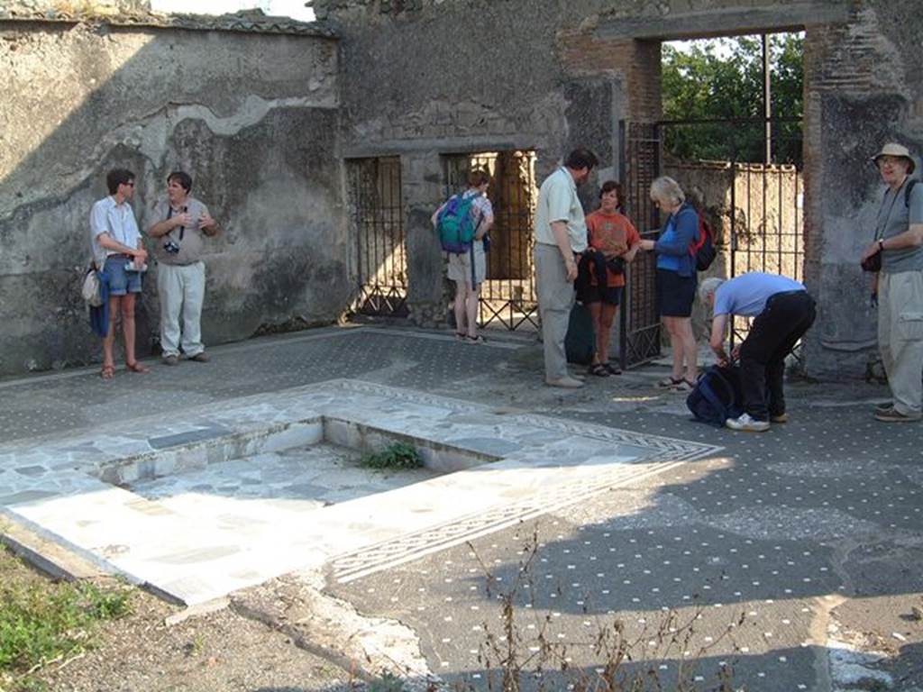 VI.1.7 Pompeii. May 2001.
Looking south-west across atrium towards doorway to VI.1.8, in centre. Photograph courtesy of Current Archaeology.
