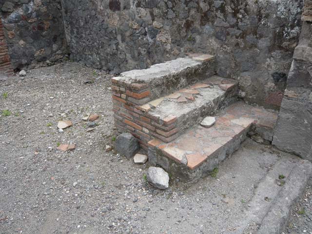 VI.1.15 Pompeii. December 2005. East wall with basins or vats.
According to Jones and Robinson, a group of small workshops were constructed in the south of the insula. Each workshop had a wide shop doorway opening onto Via Consolare. Plaster-lined tanks, similar to those found in the north of the insula, were recovered from the excavations of the Soap Factory (VI.1.14/15). They were also discovered at the Bar of Acisculus (VI.1.17) and also from the Shrine at VI.1.13. This suggested that there was a consistent phase of tank-centred industrial activity throughout the insula, and that fish processing was a major industry in this area of Pompeii during the late second and early first centuries BC.
See Dobbins, J & Foss, P., 2008. The World of Pompeii. New York: Routledge. (p.394)
On page 398, they say that following the Social War, the fish processing tanks were abandoned and the workshops redeveloped. In the Soap Factory, a group of clay and stone hearths were recovered, along with significant quantities of hammerscale, charcoal, slag and hearth bottoms.  This property was now operating as a metal smithy.

