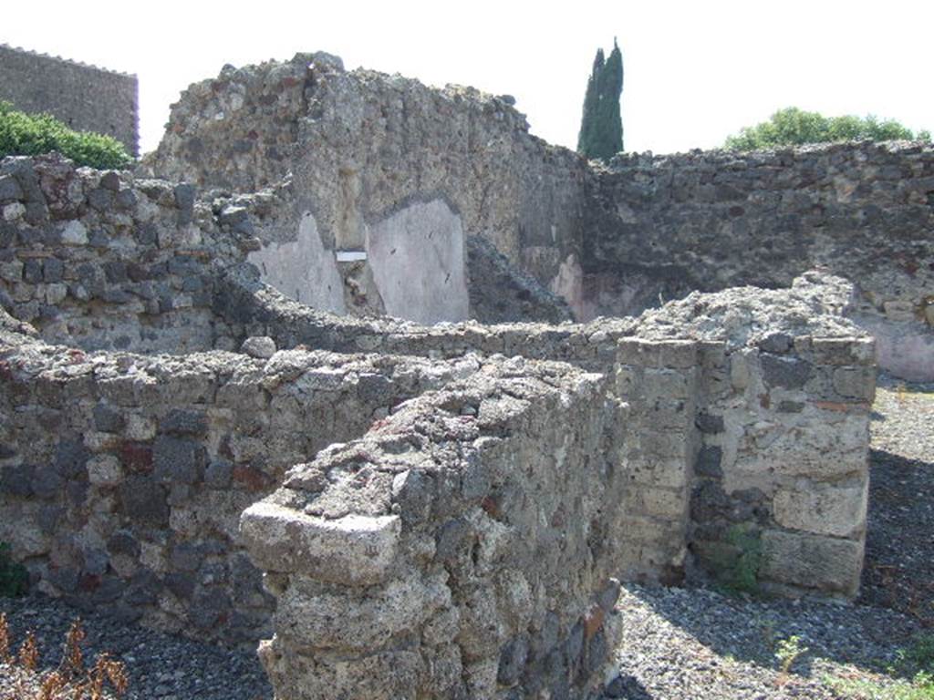 VI.2.28 Pompeii. September 2005. Looking south-west towards rear of house and small garden area. The remains of two cubicula can be seen on the left, and in the upper middle would have been the Oecus.
On the south wall of the oecus, the lararium niche can be made out, above a white shelf. At the rear of the oecus, across the rear of the house, would have been the garden area. According to Giacobello, in the south wall of the Oecus was a square niche with the residue of white plaster and shelf in marble. See Giacobello, F., 2008. Larari Pompeiani: Iconografia e culto dei Lari in ambito domestico.  Milano: LED Edizioni. (p.290)
According to Boyce, in the south wall of the oecus which opens off the garden is a rectangular niche. The walls of the niche are coated with stucco and painted green. The floor of the niche is a thick slab of marble; the reports called it la nicchia per I Penati. See Boyce G. K., 1937. Corpus of the Lararia of Pompeii. Rome: MAAR 14. (p.44, no.143) 


