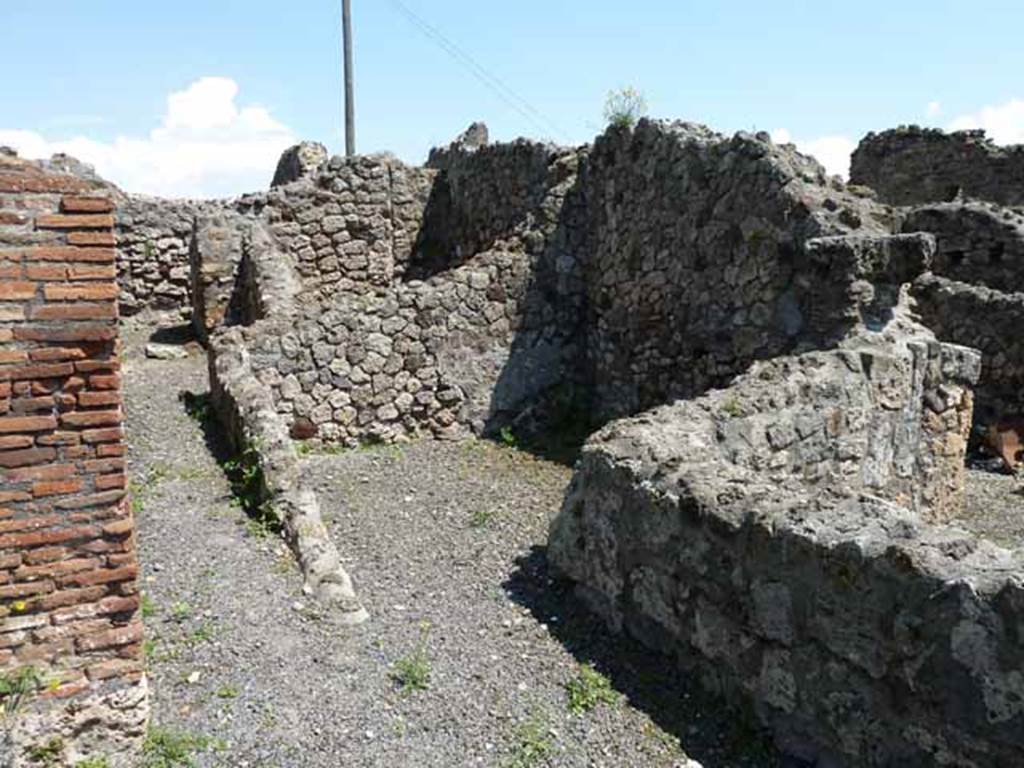 VI.3.10 Pompeii. May 2010. Passageway to rear on south side of workshop and doorway to western room.
