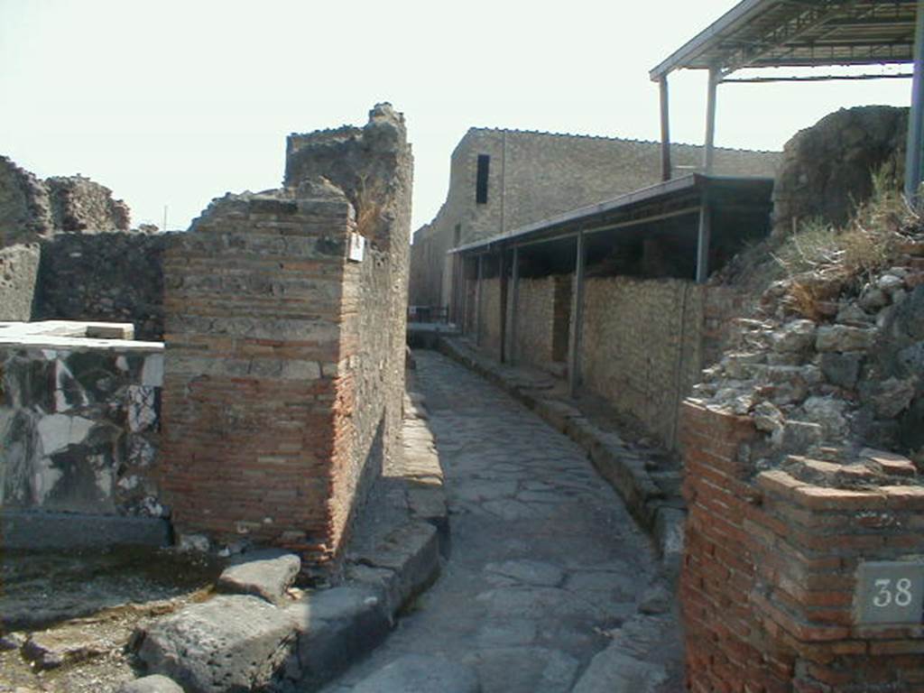 VI.4.1 Pompeii. May 2006.Thermopolium and Vicolo del Farmacista from Via Consolare, looking south.
