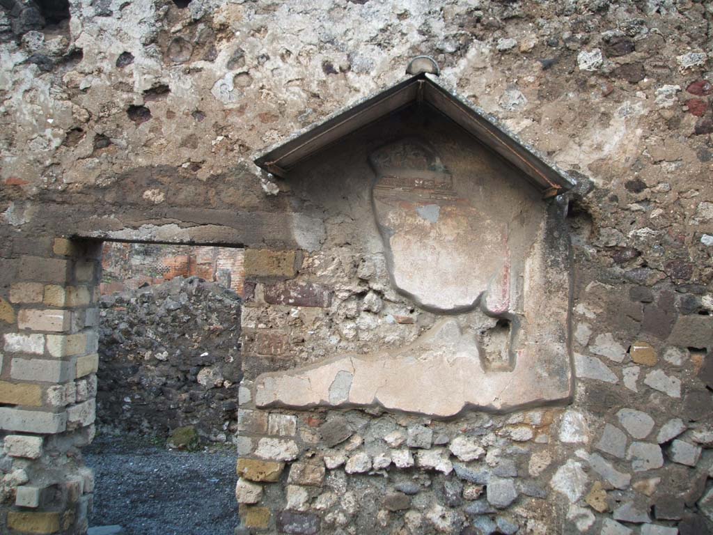 VI.4.4 Pompeii. December 2004. North wall, with remains of painted lararium shrine.
According to Boyce, above a strip of ordinary red stucco on the wall was a rectangular panel of white stucco, marked off with red stripes.
Above that was a smaller rectangle which was enclosed within the aedicula façade.
The painting within the aedicula showed the figure of the Genius standing on the right of a yellow altar.
Behind the altar stood the tibicen and towards the same altar, coiled the two serpents, one from each side.
On each side of this group stood a Lar, clad in yellow tunic, green girdle and red pallium.
These figures are standing higher than the other figures.
The lower rectangle probably also contained painted figures, but none were visible, and had not been described in previous reports.
See Boyce G. K., 1937. Corpus of the Lararia of Pompeii. Rome: MAAR 14. (p. 46, no. 151)
See also south wall, above.
