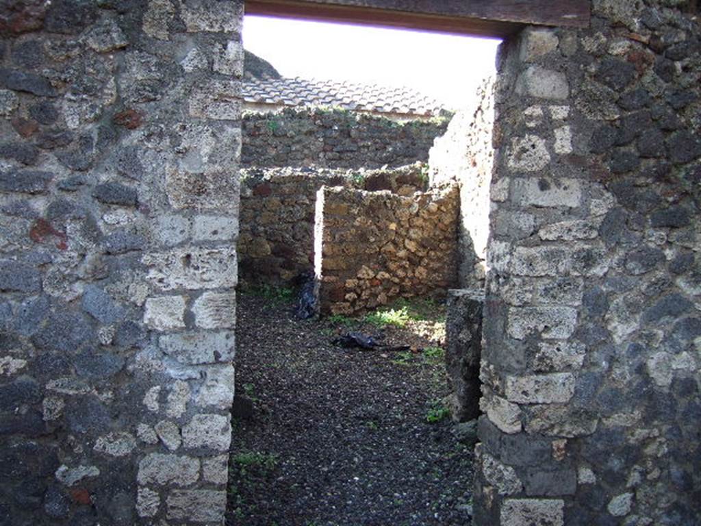 VI.5.14 Pompeii. December 2005. Looking west through doorway into kitchen area, towards latrine in north-west corner. The north-west corner of this room, the latrine, shows that today there is no doorway of  VI.5.11 here, as shown on Eschebach plan. VI.5.11, steps to an independent upper floor, is now to the north of this corner, fronting onto Vicolo di Modesto, and is completely separate from here.
According to CTP, the north-west corner of the house at VI.5.14 was excavated in 1817, as well as the pseudoperistyle of VI.5.10 and atrium area of VI.5.9. The street wall at the north-west corner of the house at VI.5.14 collapsed and was reconstructed, which may provide the reason why Tascone, Mau and Eschebach, all indicated a rear doorway of this house immediately south of the stairway, which, rightfully should be assigned a number. 
The doorway is delineated by Russos map of 1817, and later by Mazois, Fiorelli  Sorgente, and Zangemeister (1865).  Today the number VI.5.11 is not in situ but it has been assigned by the SANP to the staircase. 
See Van der Poel, H. B., 1981. Corpus Topographicum Pompeianum, Part V. Austin: University of Texas. (p.196-7)


