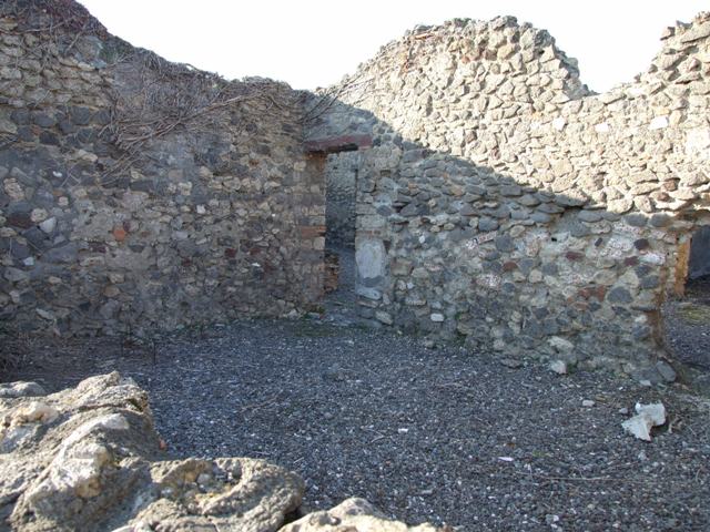 VI.7.15 Pompeii. October 2022. Looking north over wall into large room or triclinium on south side of yard. Photo courtesy of Klaus Heese.