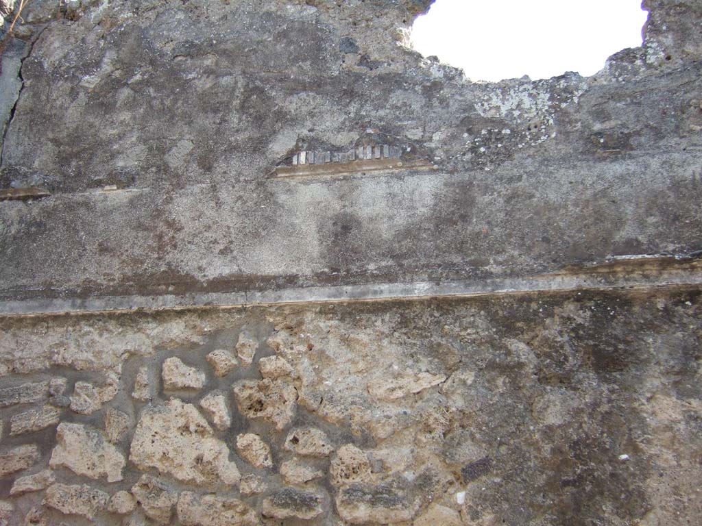 VI.7.25 Pompeii. September 2005. Remains of stucco decoration on south wall in cubiculum on north side of entrance corridor.