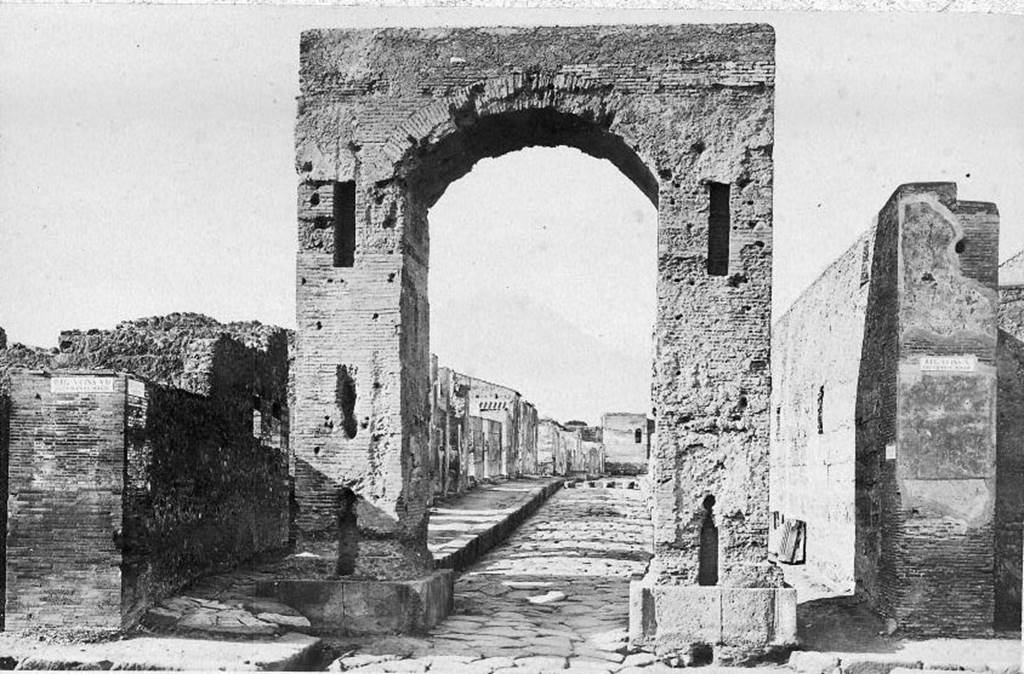 VI.8.11 Pompeii, front and side wall, on left of picture.
Looking north through Arch of Caligula along Via di Mercurio. About 1870. Photo courtesy of Rick Bauer.
According to Pagano and Prisciandaro, graffiti were found on these walls in 1824.
Found on the wall to the left of the arch was 

Hypsaeum
quinq(uennalem) d(ignum) r(ei) p(ublicae)    [CIL IV 270]

C(aium) Iulium Polybium
d(uumvirum) i(ure) d(icundo) o(ro) v(os) f(aciatis)    [CIL IV 271]

M(arcum) Lucretium [F]ro[ntonem]    [CIL IV 272]

See Pagano, M. and Prisciandaro, R., 2006. Studio sulle provenienze degli oggetti rinvenuti negli scavi borbonici del regno di Napoli. Naples: Nicola Longobardi, (p.128)
See Fiorelli G., 1862. Pompeianarum antiquitatum historia, Vol. 2: 1819  1860. Naples, p. 91.
See Fiorelli G., 1864. Pompeianarum antiquitatum historia, Vol. 3. Naples, p. 47.
