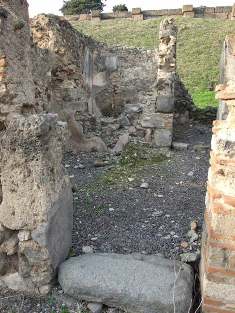 VI.9.14 Pompeii. December 2007. Corridor 29, leading to kitchen 28 in north-east corner.
At the rear of the site of the light-yard/courtyard, the small room 30 can be seen through the remains of a window. According to Packer, the wall plaster was painted red in the light-yard/courtyard area.
