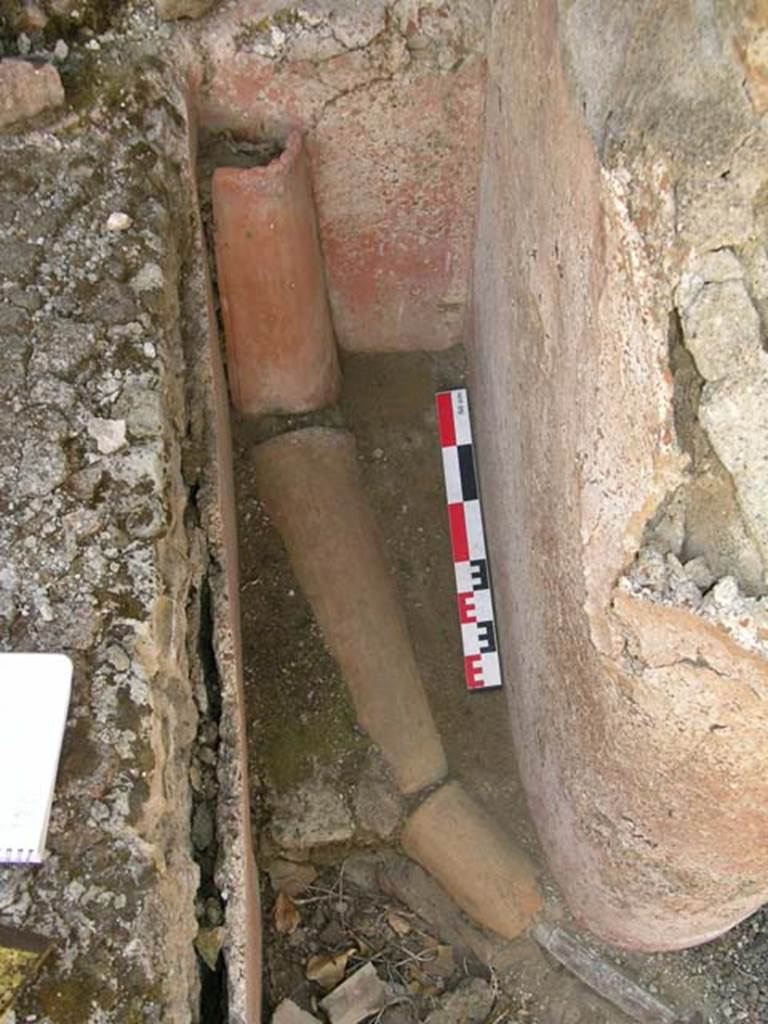 VI.14.22 Pompeii. June 2006. Room 12, terracotta and lead piping in north-west corner of peristyle. Photo courtesy of Nicolas Monteix.

