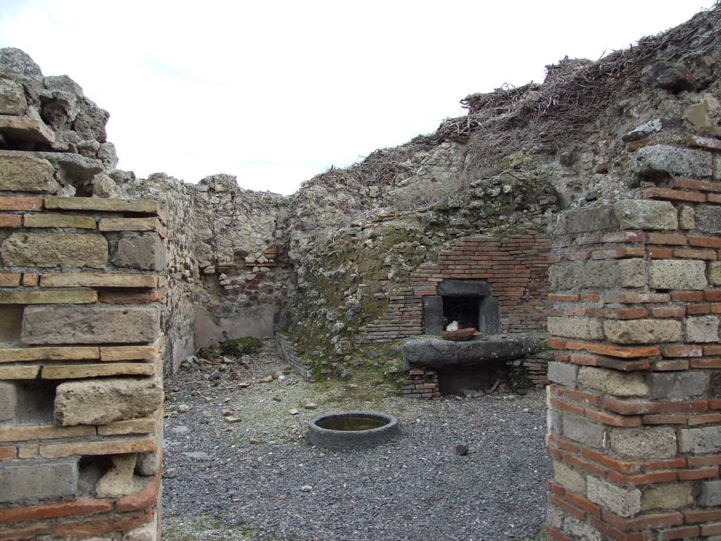 VI.14.34 Pompeii. December 2007. Looking east from atrium towards the oven in the bakery.
At the rear of the wall on the right of this entrance doorway, would be the west wall facing the oven.
According to Boyce, on the west wall facing the oven, above a low table, was a red panel in which two serpents were represented in stucco relief.
See Notizie degli Scavi di Antichità, 1876, p. 195; Bull. Inst., 1878, 196.
See Boyce G. K., 1937. Corpus of the Lararia of Pompeii. Rome: MAAR 14. (p.53, no.204, with Pl. 28,4). 

