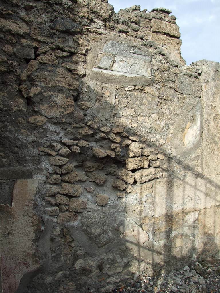 VI.14.43 Pompeii. December 2006. Remains of wall plaster on inside north (left-hand) side of entrance.