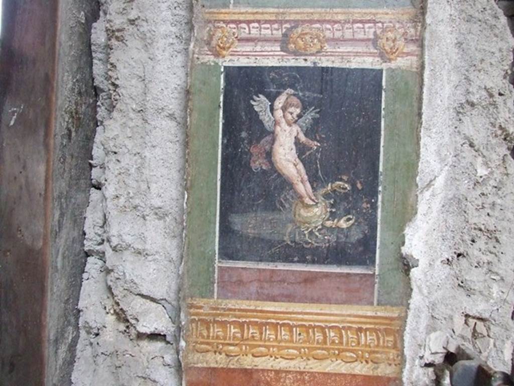 VI.15.1 Pompeii. December 2006.  Detail of painted pillar between Peristyle and Atrium showing Cherub or Cupid riding a crab.
