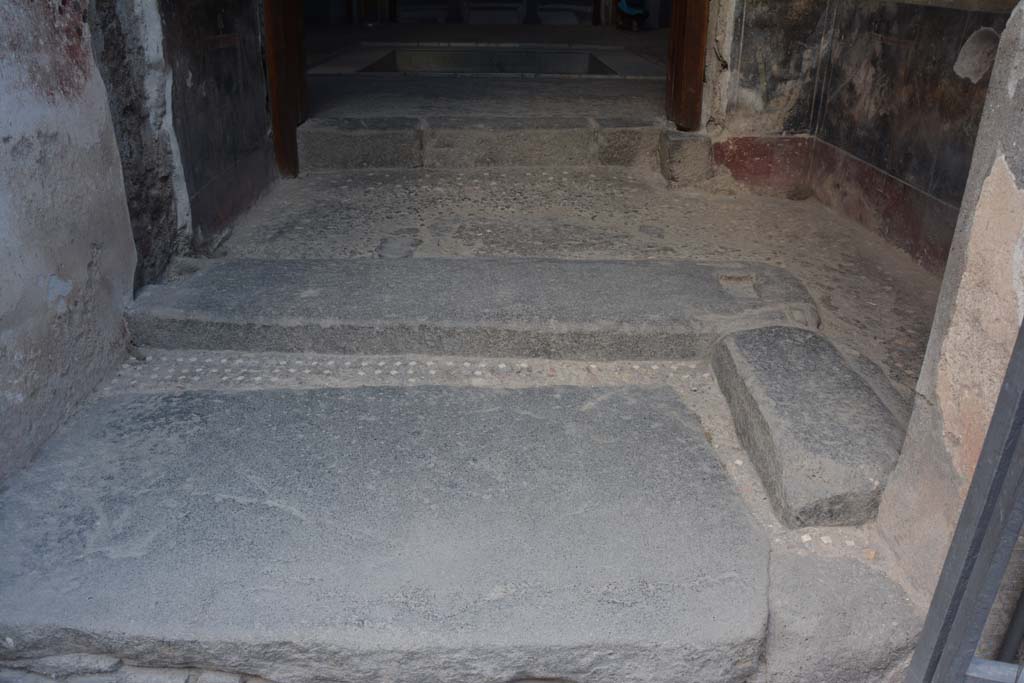 VI.15.1 Pompeii. July 2017. Looking west across doorway threshold and flooring from entrance fauces (a) to vestibule (b).
At the rear of the entrance threshold in another with rectangular recesses that would have held the main doors.
The small threshold to the right could be used to allow entry without the need to open the heavy main doors.
See Carratelli, G. P., 1990-2003. Pompei: Pitture e Mosaici: Vol. V. Roma: Istituto della enciclopedia italiana, p. 469.
Foto Annette Haug, ERC Grant 681269 DÉCOR.

