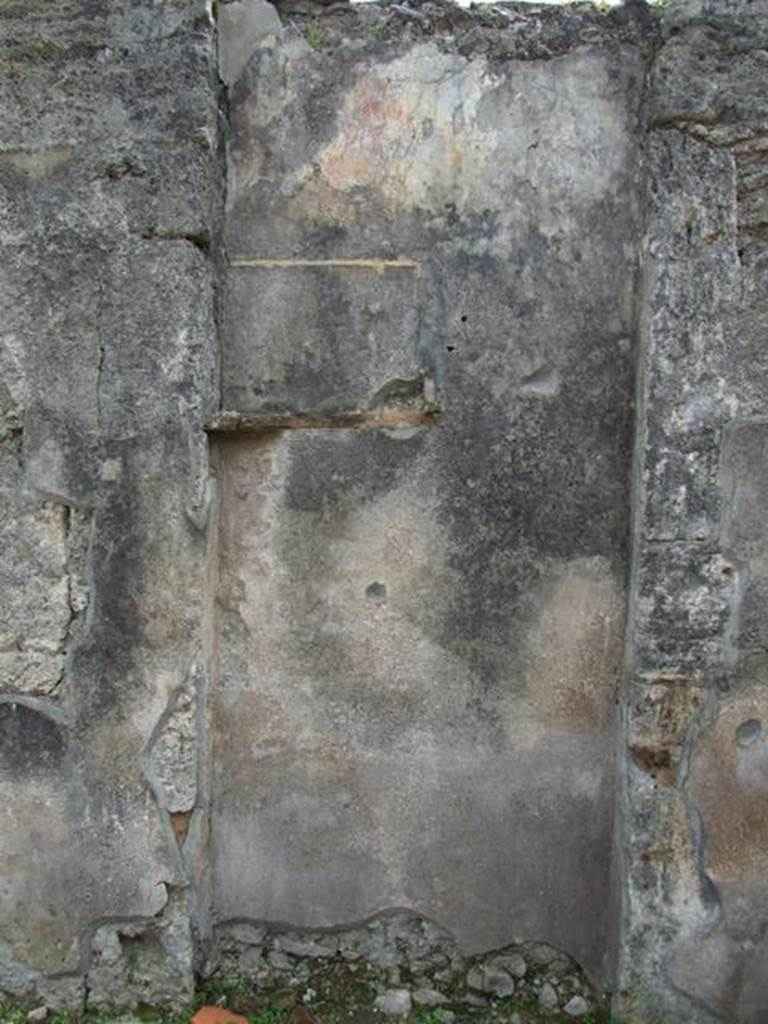 VI.16.27 Pompeii. March 2009. Room B, recess in south wall of atrium.
According to Boyce, the doorway that led from the atrium to the peristyle was walled up, leaving a shallow recess in the south wall.
Within this recess, in the upper left corner, a white panel was marked off by green stripes on both sides. The figure of Jupiter was painted on the panel. He was seated upon a throne, leaning his forehead against his left hand, through the bend of this arm passed a long sceptre.
The lower end of the sceptre rested on the ground., in his right hand he held the thunderbolt. His feet were placed on a footstool and to its left stood an eagle. In the wall below the panel were embedded two broken tiles, one horizontal, the second perpendicular to the first at its west end. The wall space between the painting of Jupiter and the two tiles was decorated with plants painted on a yellow background. The horizontal tile may have served as a shelf for offerings, but the purpose of the two tiles was not clear. Found near the shrine was a terracotta votive altar. Not. Scavi, 1908, 184.  See Boyce G. K., 1937. Corpus of the Lararia of Pompeii. Rome: MAAR 14. (p.59, no.226)
