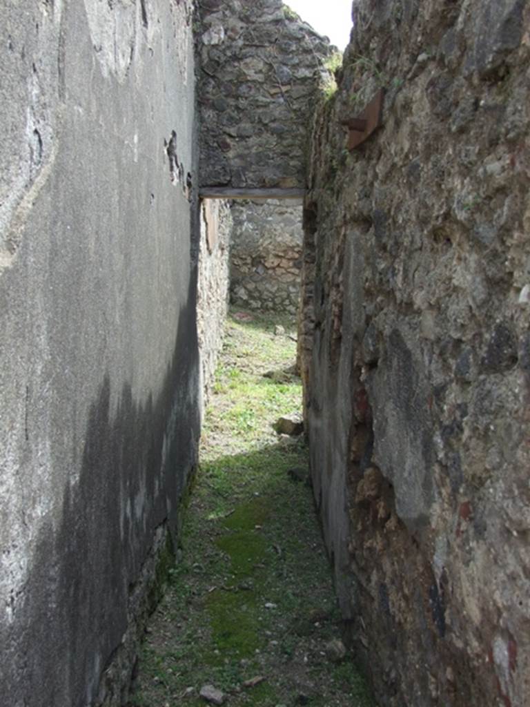 VI.16.27 Pompeii. March 2009. Corridor leading south towards rooms Y, Z and A. According to NdS, this corridor ran south behind the west side of the peristyle. Its walls were similarly painted to the fauces, imitating slabs of marble with black and white vertical streaks.
