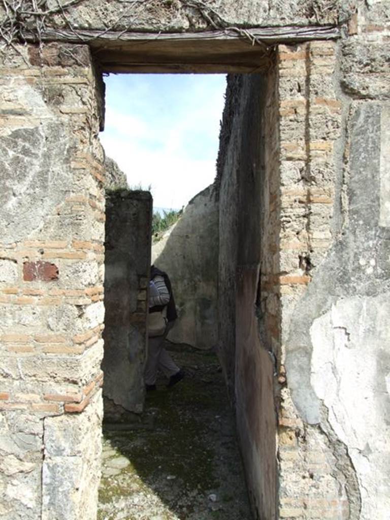 VI.16.28 Pompeii. March 2009. Doorway to rooms G and H. According to NdS, to the side of the tablinum were two rather narrow rooms, with lava threshold and showed remains of wood towards the atrium. The doorway on the left, which preserved in the threshold the two iron hinges, led into room G, which was a small rustic room. Its floor was made of cocciopesto, and had rough plaster on the walls, except on the south wall which formed a continuation from the atrium.  See Notizie degli Scavi di Antichit, 1908, (p.277)
