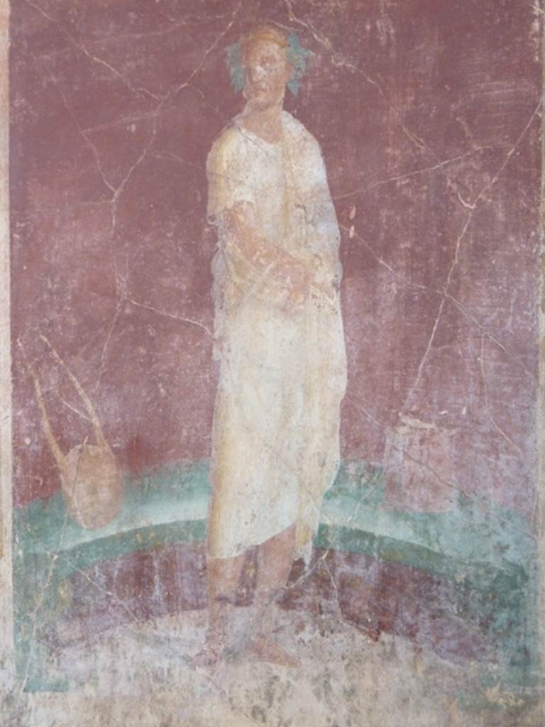 VI.17.41 Pompeii. October 2010. east wall of exedra 18 on north side of cubiculum 17. 
Detail of painting of robed figure with instruments. Photo courtesy of Gaby Groe.

