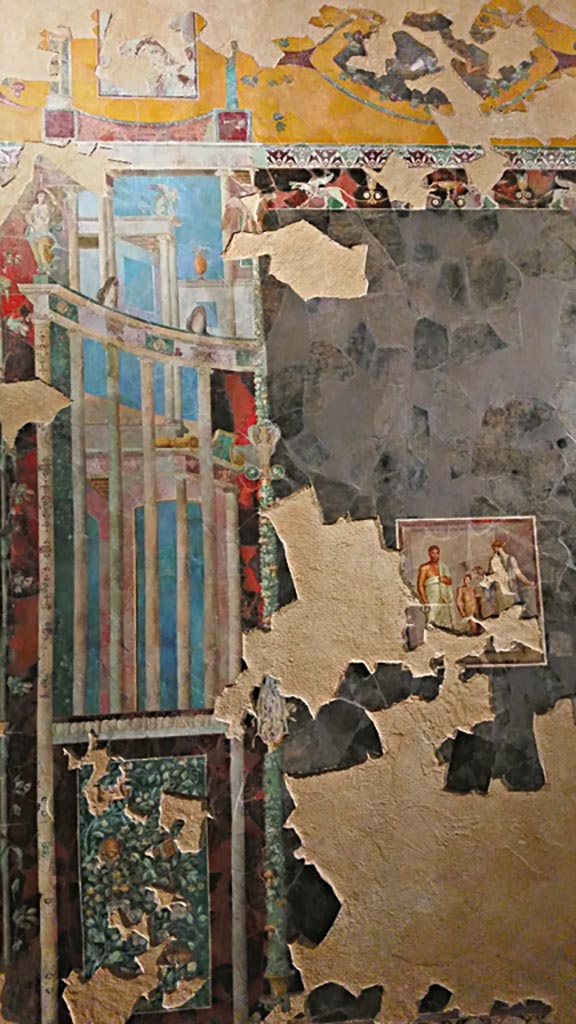 VI.17.42 Pompeii.  Fragments of a dining room fresco from the centre of a wall, thought to be the poet Euphorion.
A female (poetess?) is reading a diptych, and a boy with a red cloak has a plate for offerings.
Parco Archeologico di Pompei, inventory number 86075. 
This is part of a larger panel, one of several items recomposed from a large number of fragments found in a channel in the garden. 
It is thought to be from the reconstruction work following the damage after the earthquake of AD62. 
Its original room location is unknown.
See Aoyagi M. and Pappalardo U., 2006. Pompei (Regiones VI-VII) Insula Occidentalis. Napoli: Valtrend. (p. 222-7).
