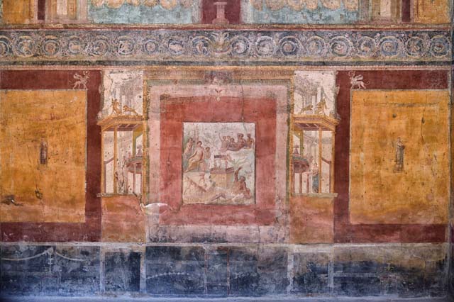 VII.1.47 Pompeii. May 2017. Exedra 10, detail from central painting on north wall.
On the right, half way up a mountain, sits Bacchus, surrounded by his attendants.  
Photo courtesy of Buzz Ferebee. 
