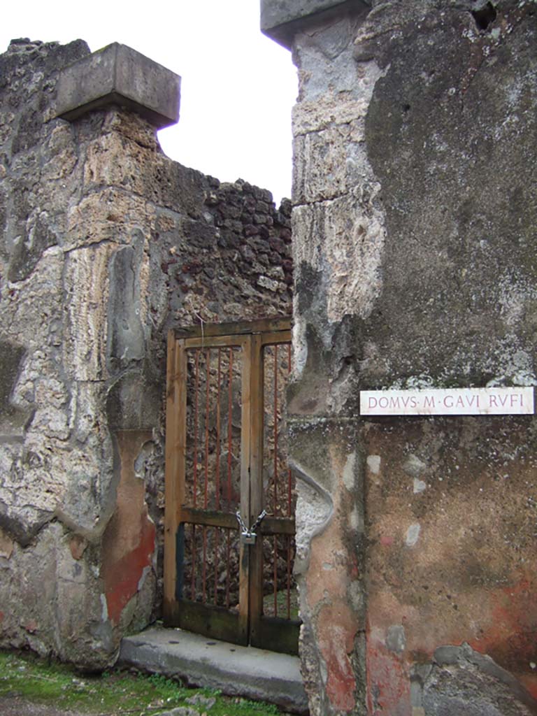 VII.2.16 Pompeii. December 2005. Entrance, with cubic tufa capitals.
Della Corte thought that the identification of the owner of this house as being M. Gavi Rufi should be rejected.
The identification was based on two inscriptions found on the red plaster at the sides of the doorway
M. GAVI. DOMVS    on the left, and
RVFII VA(le)   [CIL IV 2319f]  on the right between VII.2.16 and VII.2.17.
Therefore, he said, this house owner should remain anonymous.
Fiorelli thought these inscriptions gave the ownership of the house, without doubt, to duumvir M. Gavio Rufo.
See Della Corte, M., 1965. Case ed Abitanti di Pompei. Napoli: Fausto Fiorentino. (p.154)
See Pappalardo, U., 2001. La Descrizione di Pompei per Giuseppe Fiorelli (1875). Napoli: Massa Editore. (p.81)

Also found on the wall of the house, according to Cooley,
Marcus Vecilius Verecundus, outfitter.  [CIL IV 3130]
See Cooley, A. and M.G.L., 2004. Pompeii: A Sourcebook. London: Routledge. (p.176, H55)
According to Della Corte, the graffito was found on a column in the house:
M. Vecilius Verecundus, Vestiar(ius)      [CIL IV 3130]
See Della Corte, M., 1965. Case ed Abitanti di Pompei. Napoli: Fausto Fiorentino. (p.280)

Also found on the wall between VII.2.16 and shop at VII.2.17,
Vesbinus cinedus, Vitalio pedicavit     [CIL IV 2319b]
See Varone, A., 2002. Erotica Pompeiana: Love Inscriptions on the Walls of Pompeii, Rome: L’erma di Bretschneider. (p.137)
