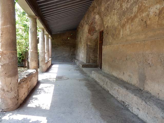 VII.5.24 Pompeii. June 2012. Men’s baths apodyterium or changing room (14), looking north. 
Photo courtesy of Michael Binns.
According to Fiorelli –
The changing room (14), other than the doorway from the fauces (corridor 16, on right above), had another five doorways around it. 
On the right of the corridor 16, (centre, above) was a small room where the oils and ointments were stored.
On the left of the photo above (west) was the doorway to the long corridor leading to the boiler area.
On the left (behind the figure) was also the third doorway which led into the tepidarium (37).
The fourth doorway (in the south-west corner) led into the frigidarium (19)
The fifth doorway (in the south-east corner) led into corridor 13, leading towards the garden/courtyard area, which had two secondary entrances or exits towards the east and west sides of the Insula.
See Pappalardo, U., 2001. La Descrizione di Pompei per Giuseppe Fiorelli (1875). Napoli: Massa Editore. (p.94-95).


