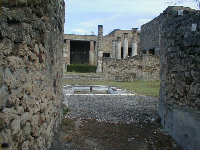 VII.7.5 Pompeii. September 2004. Looking north-east across impluvium in atrium (b), from entrance corridor (a).

