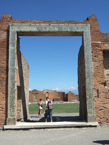 VII.9.1 Pompeii. September 2005.Portico 1. North end. Plaque to Romulus, son of Mars, situated below niche between entrance and apsidal niche 4. ROMULUS MARTIS FILIUS URBEM ROMAE CONDIDET ET REGNAUIT ANNOS DUODEQUADRAGINTA….. See Engelmann, W., 1929. New Guide to Pompeii: Second Edition. Engelmann. (p.170). See Pompeii, A Sourcebook by Alison Cooley, (p.101), E45, CIL X 809 = ILS 64.