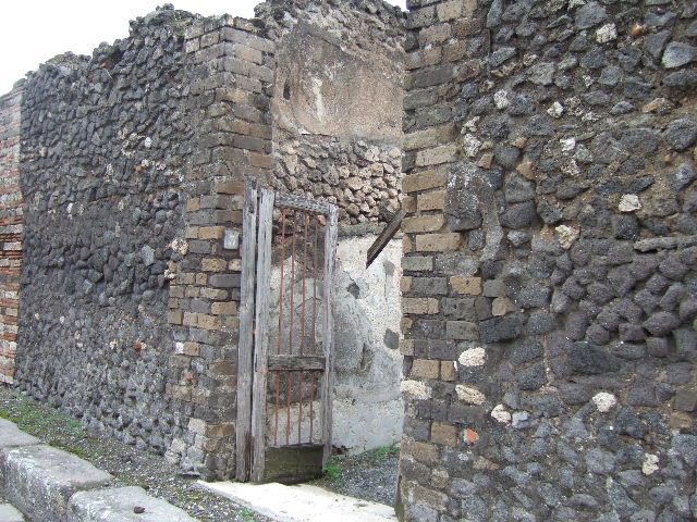 VII.10.3 Pompeii. December 2005. Looking east from entrance, through entrance fauces or corridor, 1. The doorway to the cella ostiaria (room 2) opened in the south-west (on the right). The entrance corridor was found with a floor of simple cocciopesto. The walls were covered with white plaster. 

