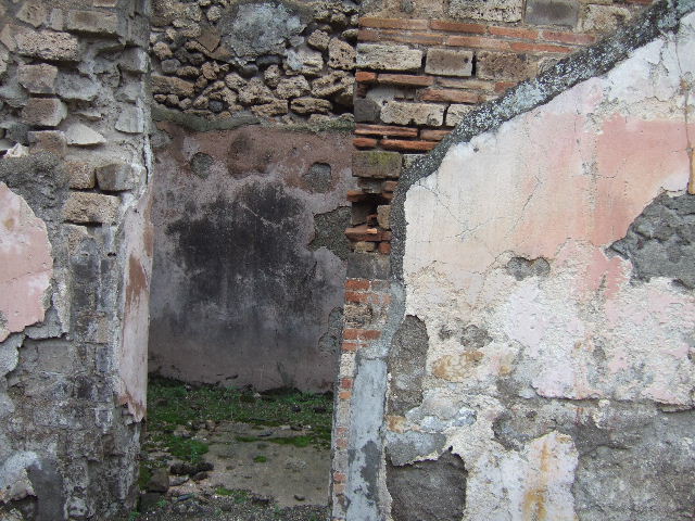 VII.10.3 Pompeii. December 2005.  Looking south through doorway of room 9 towards doorway of room 22, possibly a small storeroom, on right. Looking south across room 9, a triclinium which originally had a floor of cocciopesto. According to Amoroso, the walls of room 9 were recovered with painted plaster made of wide red and yellow sections, separated by white panels. The zoccolo was painted with plant motifs. 
Studi della Soprintendenza archeologica di Pompei, 22: l”Insula VII, 10 di Pompei , by Angelo Amoroso. (p.74) 
