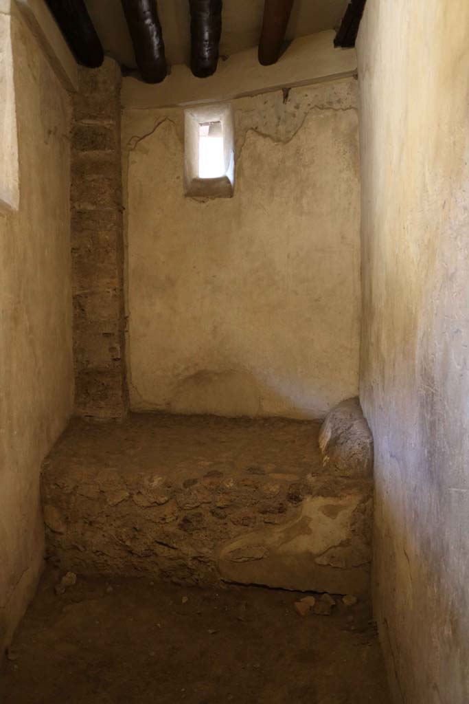 VI.12.18 Pompeii. April 2022. Stone bed in room used by prostitute, on south side at east end. Photo courtesy of Giuseppe Ciaramella.