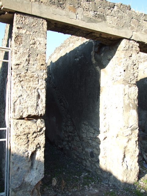 VII.15.13 Pompeii. Kitchen with altar and Genius Lar relief on east wall.
Old undated photograph courtesy of the Society of Antiquaries, Fox Collection. A Lar can be made out in the top left hand corner, and a hog’s head on the right side of the altar.