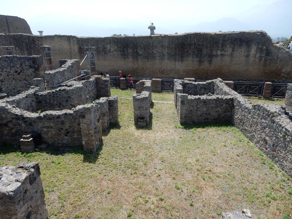 VII.16.3, Pompeii, June 2019. Looking south across the atrium towards entrance doorway, on right.
Photo courtesy of Buzz Ferebee.
According to Fiorelli, 
“Segue una piccola casa, alla quale era annessa la bottega che viene dopo. Nel protiro a sinistra vedesi un dormitorio, ed a destra la porta di comunicazione con la menzionata taberna. Indi l’atrio tuscanico con impluvio di fabbrica, e la bocca della cisterna di pietra vesuviana: sul destro lato un cubicolo, il tablino, una cella rustica, e da ultimo un angusto e basso repositorio, che anteriormente aveva dovuto essere sottoposto ad una gradinata di fabbrica, scomparsa allorquando furono pure rasate le mura del triclinio, che trovavasi in fondo del l’atrio.”
See Pappalardo, U., 2001. La Descrizione di Pompei per Giuseppe Fiorelli (1875). Napoli: Massa Editore. (p.161)
(translation: “Following on we have a small house, which was annexed to the shop that came after. On the left of the prothyron/entrance corridor we see a doorway into a dormitory, and on the right a doorway with communication to the above-mentioned shop. Then comes the tuscanic atrium with the masonry impluvium, and the cistern-mouth made of Vesuvian stone: on the right side was a cubiculum, the tablinum, a rustic room and last, a narrow and low repository that formerly must have been underneath a masonry staircase, lost at the time when they were adapting the wall of the triclinium, which was found at the rear of the atrium.”)
