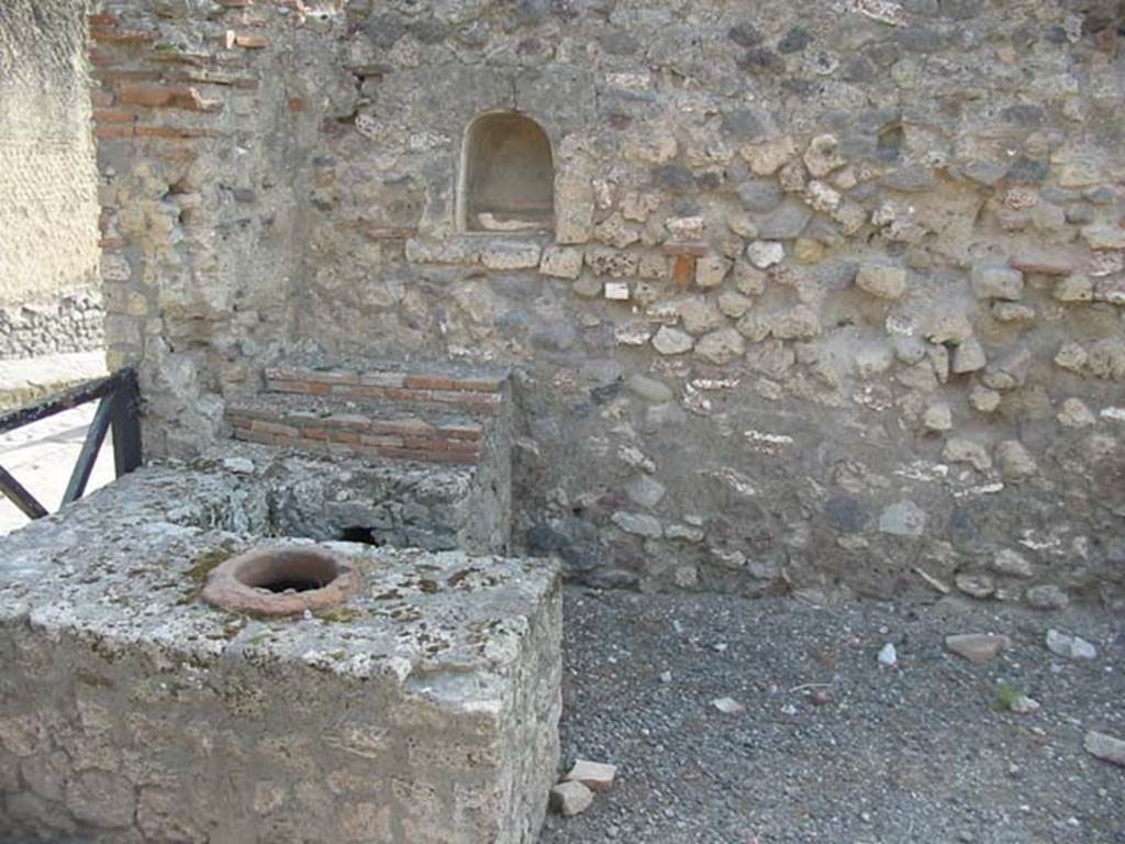 VII.16.7 Pompeii. December 2006. Two arched niches, display shelving and counter with urn.
