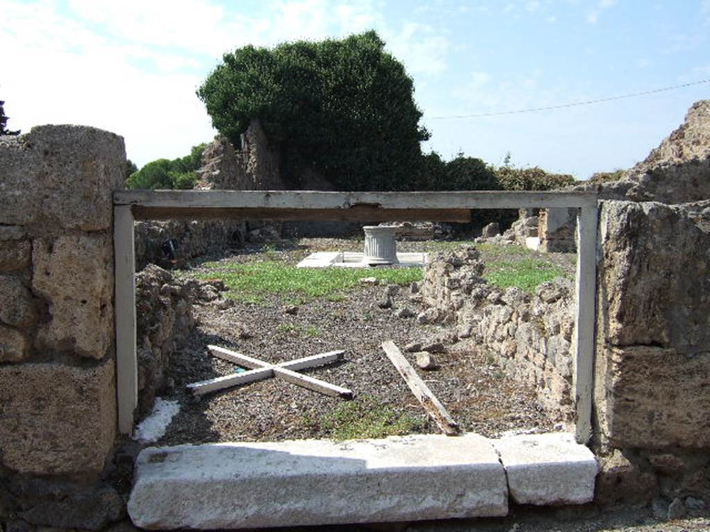 VII.16.10 Pompeii. September 2005. Looking west towards atrium from entrance doorway with marble sill. According to Fiorelli, in the Tuscanic atrium was a travertine impluvium, and on the left of the entrance was a doorway to a room. To the right of the entrance, was a doorway into the shop at VII.16.11, which seemed to have originally been the triclinium. On the same side, north of the atrium, was a cubiculum, an ala, and a rustic room that may have been the kitchen.  In this last room was found a staircase to access the upper floor.  Facing the entrance was the tablinum. This had two paintings now faded and lost, one was the likeness of Europa on the Bull, the other a feminine figure, that held out a papyrus to a sitting man.  In front of the tablinum there was a base of material that may have held the arca or money chest. Adjoining was an oecus that also had a doorway from the atrium, and this was decorated with three paintings of major proportions, of which only two were visible. One represented Perseus and Andromeda, the other Drunken Hercules with Omphale. Omphale was accompanied by two maidservants and they looked down on him from on high. Also in the painting were cupids that harassed Hercules and raised up his weapons.
See Pappalardo, U., 2001. La Descrizione di Pompei per Giuseppe Fiorelli (1875). Napoli: Massa Editore. (p.161)
See Helbig, W., 1868. Wandgemälde der vom Vesuv verschütteten Städte Campaniens. Leipzig: Breitkopf und Härtel. (123, 1137, 1189, 1393b)
See Ragghianti, C.L., 1963. Pittori di Pompei. Milano: Edizioni del Milione, (p.47, fig 120, 121)
See Aoyagi, M, and Pappalardo, U. & others, 2006. Pompei, Reg.VI-VII, Insula Occidentalis. Valtrend Editore (p.543), article by Ivan Varriale.
