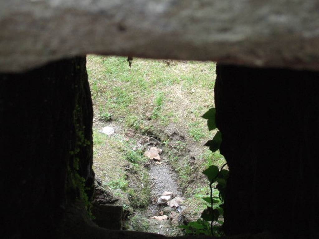 View through drain on Vico dei Soprastanti outside VII.16.17, Pompeii.