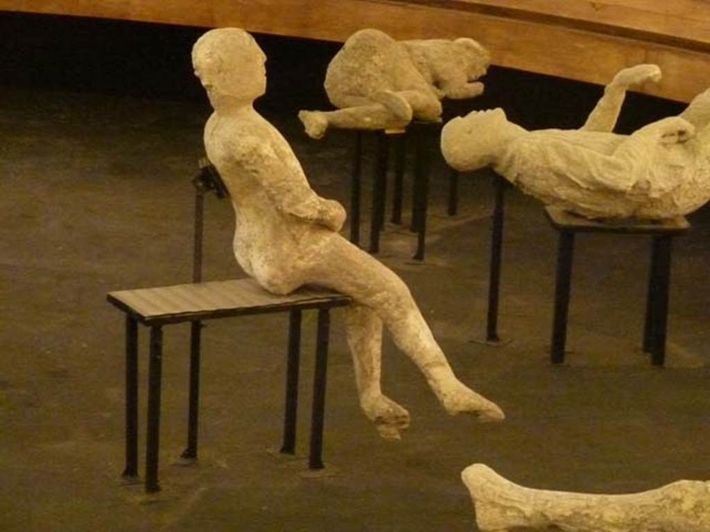 VII.16.17-22 Pompeii. September 2015. Exhibit from the Summer 2015 exhibition in the amphitheatre. Plaster cast of a body found huddled together with the others on the stairs that led to the ground floor.

