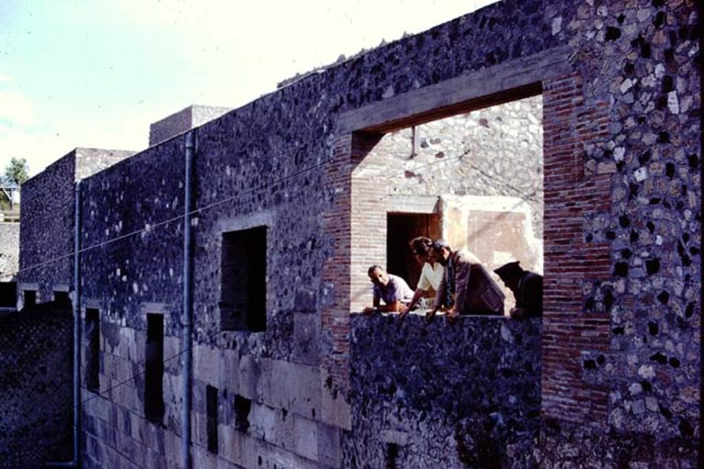 VII.16.17-22 Pompeii. 1972. Sig. Sicignano, Wilhelmina, Dott. Giordano and custodian looking from large window in west wall.  Photo by Stanley A. Jashemski. 
Source: The Wilhelmina and Stanley A. Jashemski archive in the University of Maryland Library, Special Collections (See collection page) and made available under the Creative Commons Attribution-Non Commercial License v.4. See Licence and use details. J72f0227
