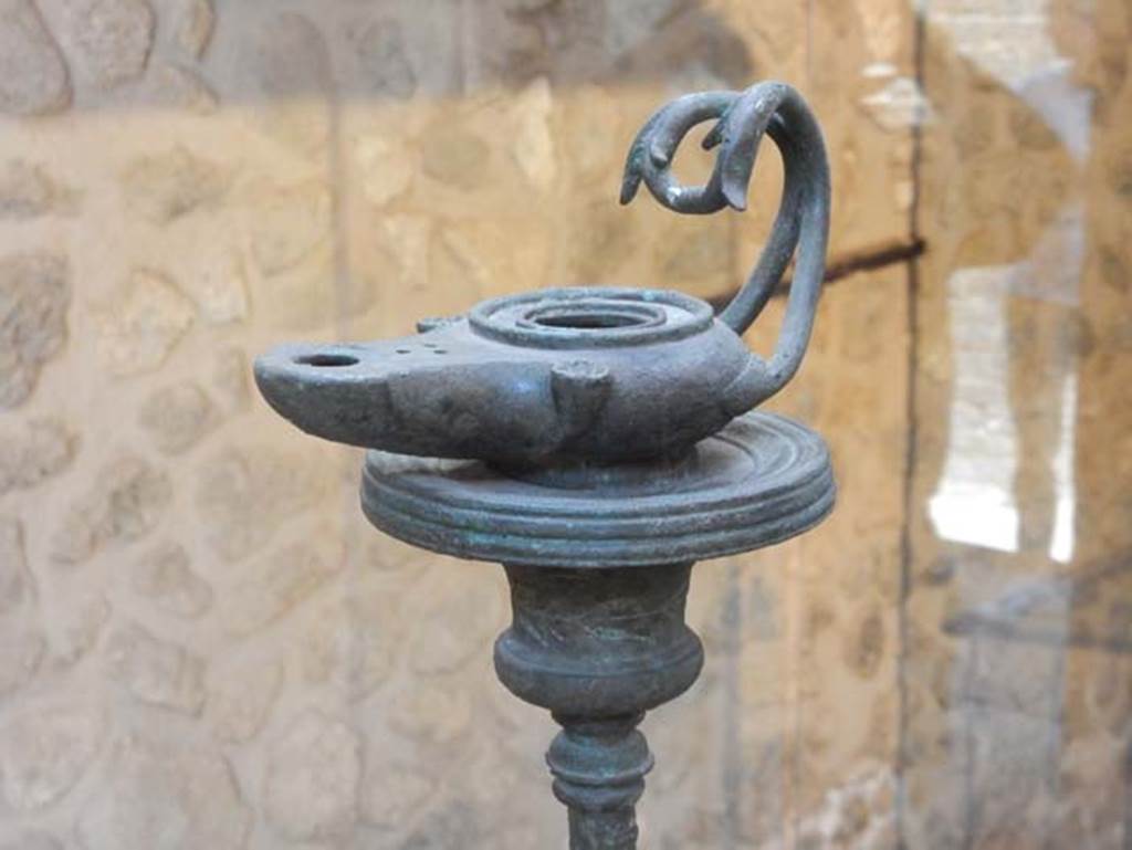 VIII.2.1 Pompeii. May 2018. Bronze lamp at the top of a tall lamp stand.
Photo courtesy of Buzz Ferebee.
