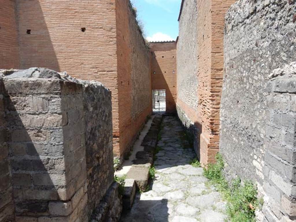 VIII.2.7 Pompeii. May 2018. Looking north-west towards high wall of VIII.2.6 with small area at rear of VIII.2.6, in centre. The passageway to VIII.2.7 is on the right.  Photo courtesy of Buzz Ferebee.
